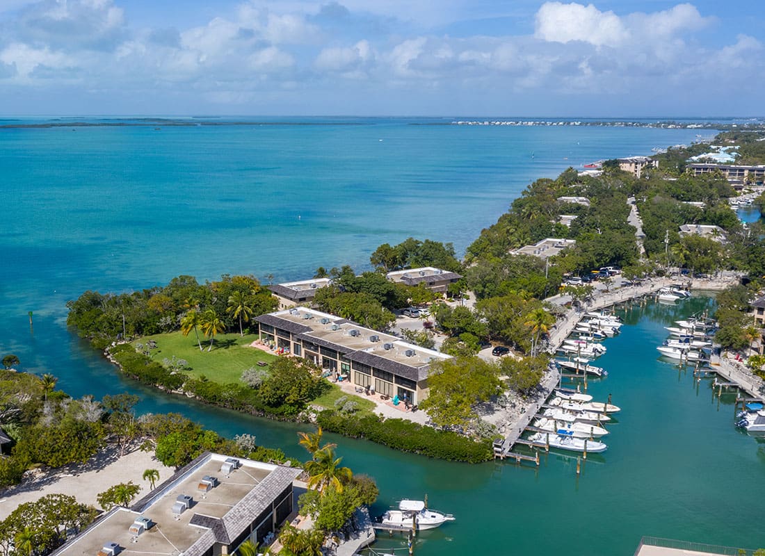 Key Largo, FL - Aerial View of Homes and Buildings on the Coastline with Boats on the Water on a Sunny Day in Key Largo Florida